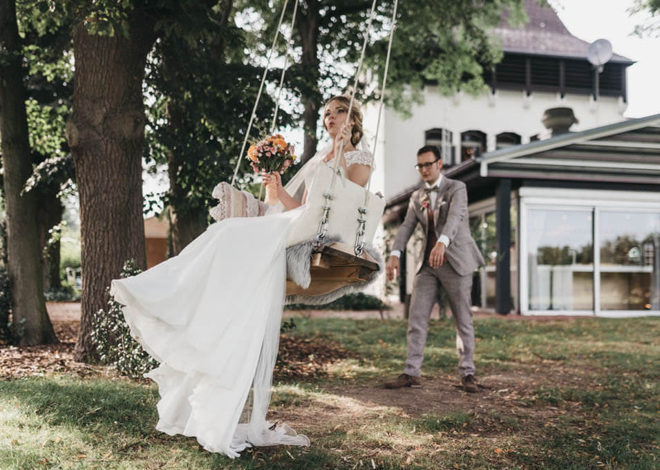 Hochzeitsfotograf Geblendet Fotografie im Herrenhaus Buchholz Bornheim - Braut schaukelt und wird von Bräutigam angeschubst
